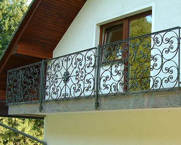 Balkonska ograja z bogatim baričnim vzorcem iz tolčenih ("kovanih") materialov, montirana na čelo balkona