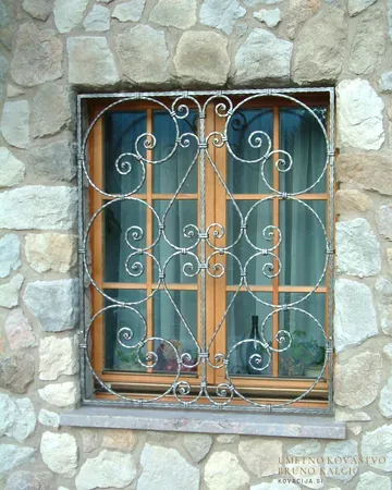 Bogate in masivne okenske mreže na kamnitem zidu