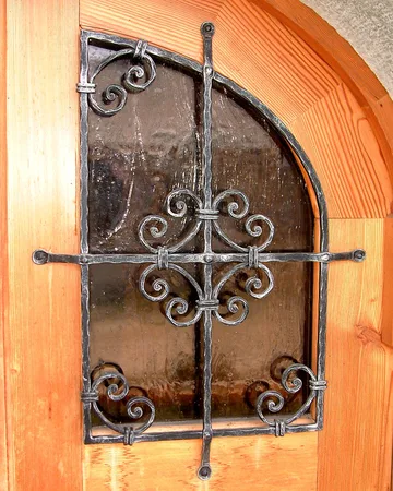 Okenski mreži na vratih, isti vzorec se ponovi tudi na ograji pred vhodom