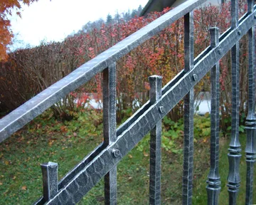 Kovana ograja ob vrtnem stopnišču, Bled, Palice s figuro so kovane iz paličnega jekla 25×25 mm
