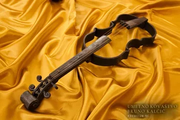Violina, izkovana v temnem jeklu in položena na rdeč žamet