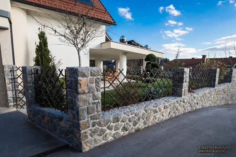 Moderna kovana dvoriščna vrata in ograja med kamnitimi stebri, Ljubljana